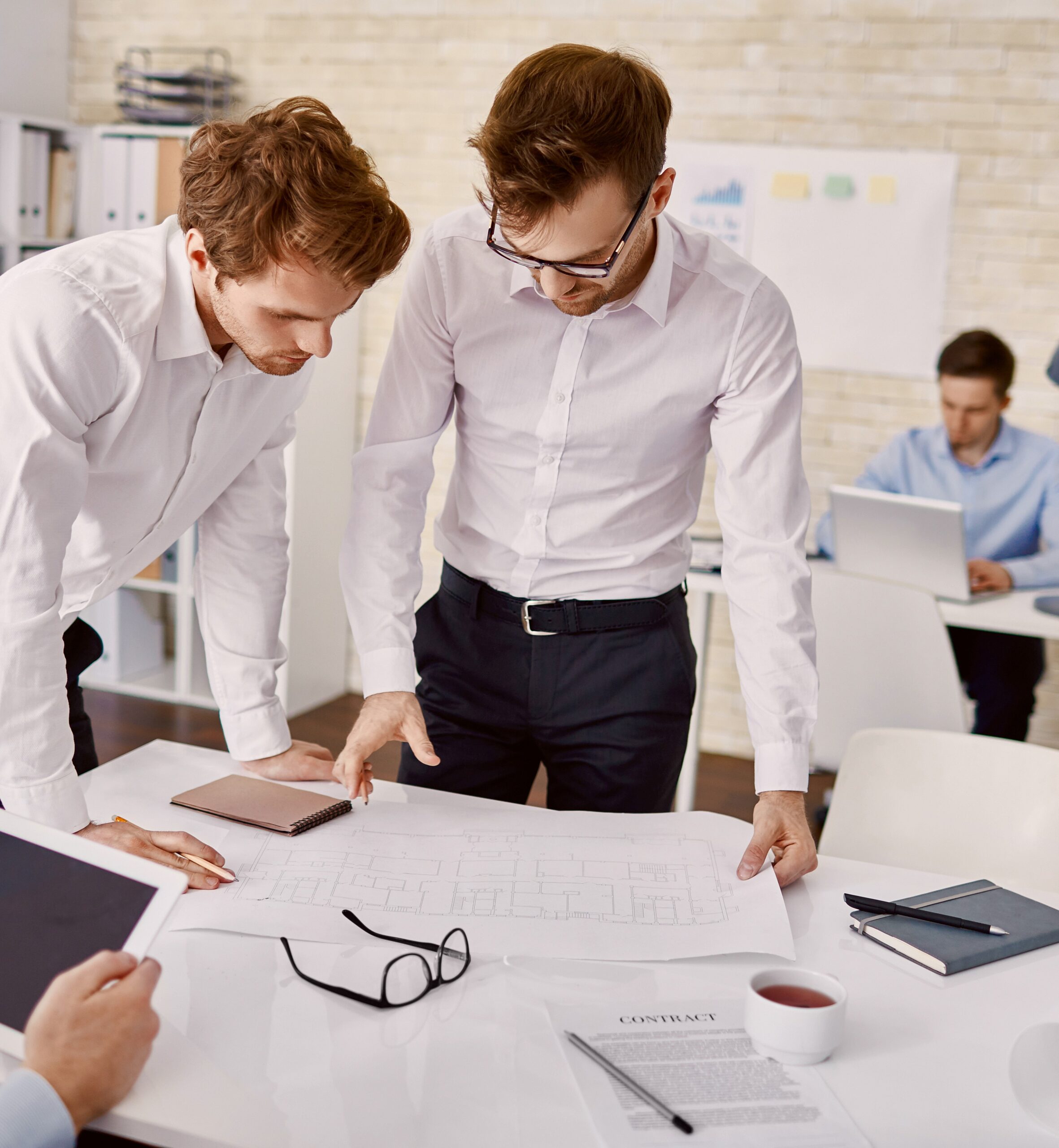 Young architects examining blueprint together at office